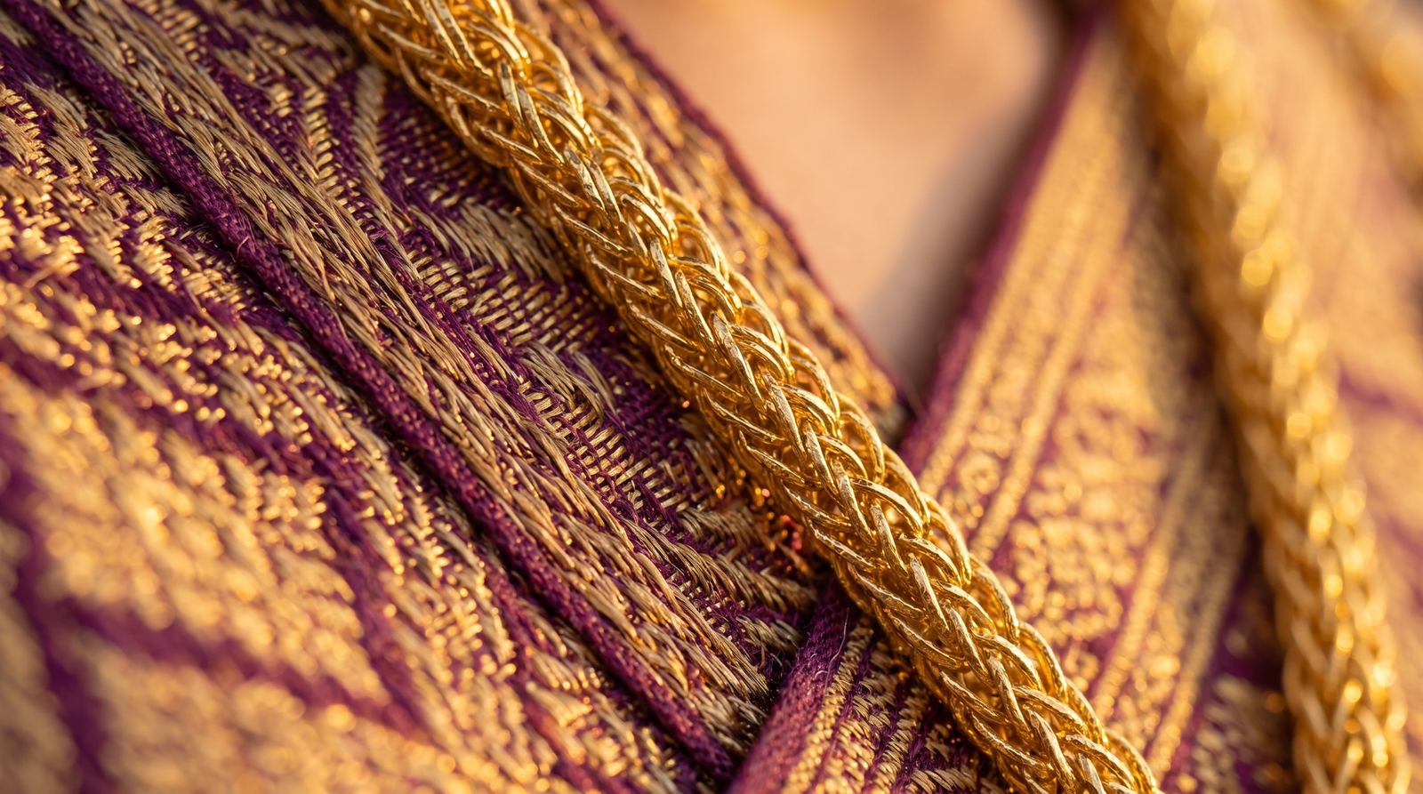 Macro of gold embroidery and jewelry